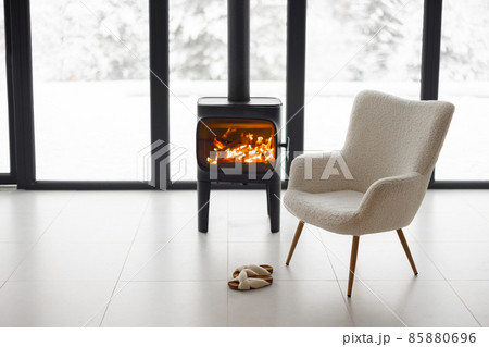 Cozy living space by the burning fireplace at snowy mountains 85880696