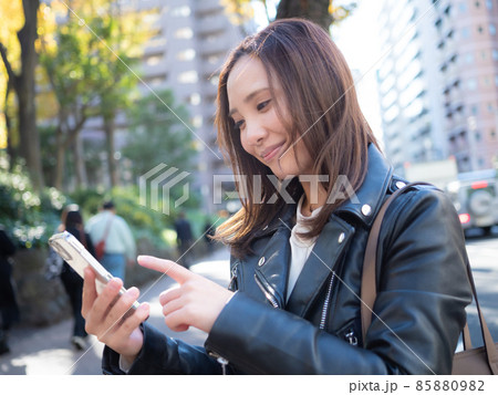 【都会】町中でスマホを操作する女性 【都会】町中でスマホを操作する女性 85880982