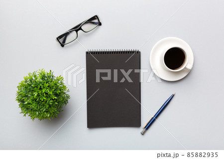 Modern office desk table with notebook and other supplies with cup of coffee. Blank notebook page for you design. Top view, flat lay Modern office desk table with notebook and other supplies with cup of coffee. Blank notebook page for you design. Top view, flat lay 85882935