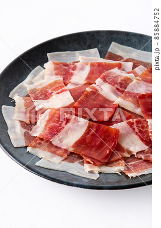 Spanish serrano ham slice on black plate Spanish serrano ham slice on black plate 85884752