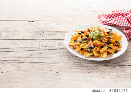 Mexican nachos tortilla chips with black beans, guacamole, tomato and jalapeno 85885176