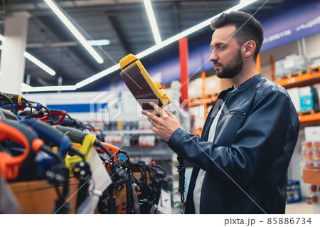 shoppers in a hardware store in the power tool department choose a wood sanding machine shoppers in a hardware store in the power tool department choose a wood sanding machine 85886734