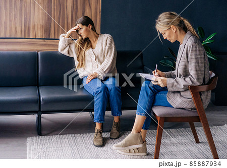 An upset woman in an emotional crisis and a psychotherapist consultant in the office. 85887934