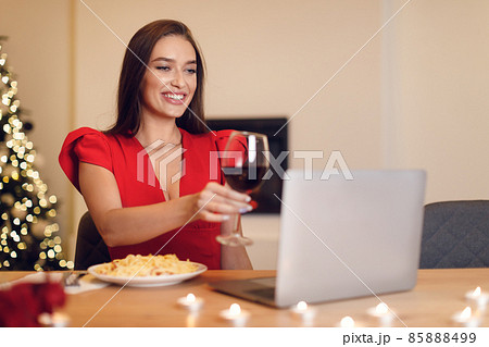 Excited woman having dinner during virtual date on laptop Excited woman having dinner during virtual date on laptop 85888499
