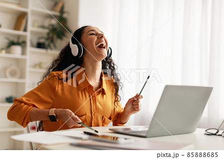 Lady Wearing Earphones Pretending Playing Drums Sitting At Laptop Indoor Lady Wearing Earphones Pretending Playing Drums Sitting At Laptop Indoor 85888685