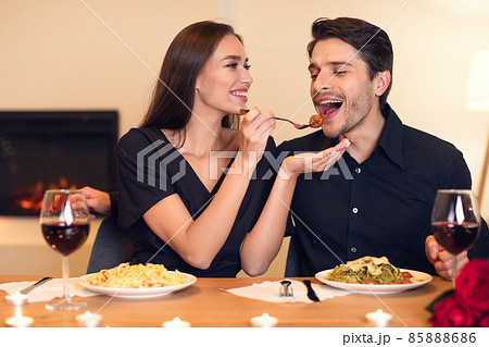 Smiling woman feeding her man with pasta Smiling woman feeding her man with pasta 85888686