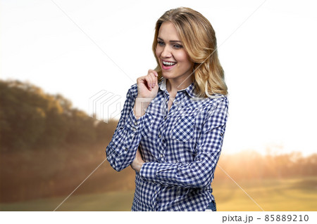 Pretty pensive girl with sly and cunning smile standing outdoors. Pretty pensive girl with sly and cunning smile standing outdoors. 85889210