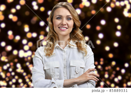 Pretty smiling woman in white blouse looking at camera with crossed arms. Pretty smiling woman in white blouse looking at camera with crossed arms. 85889331