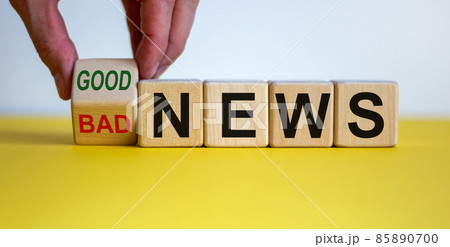 Good or bad news. Hand flips a cube and changes the words 'bad news' to 'good news'. Beautiful yellow table, white background. Business concept. Copy space. Good or bad news. Hand flips a cube and changes the words 'bad news' to 'good news'. Beautiful yellow table, white background. Business concept. Copy space. 85890700