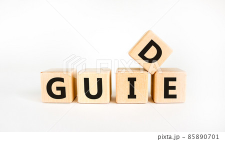 Guide and support symbol. The concept word 'guide' on wooden cubes on a beautiful white table. White background. Business and guide and support concept. Guide and support symbol. The concept word 'guide' on wooden cubes on a beautiful white table. White background. Business and guide and support concept. 85890701