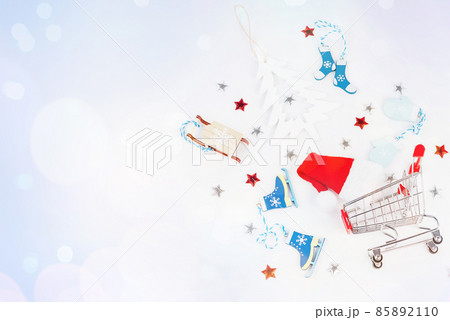 Trolley from a supermarket with New Year's gifts and New Year's toys on a light background.Flat lay, top view, wide banner.Christmas and New Year background. Trolley from a supermarket with New Year's gifts and New Year's toys on a light background.Flat lay, top view, wide banner.Christmas and New Year background. 85892110