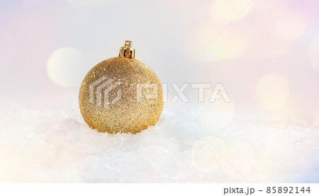 Golden shiny Christmas ball on the snow on a light background.Christmas and New Year Glitter,Shiny background.Christmas composition.Christmas,winter,new year concept.home decor.New Year's decorations. Golden shiny Christmas ball on the snow on a light background.Christmas and New Year Glitter,Shiny background.Christmas composition.Christmas,winter,new year concept.home decor.New Year's decorations. 85892144