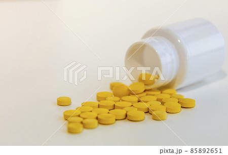 Vitamins for prevention, yellow pills prescribed by a doctor fell out of the container 85892651