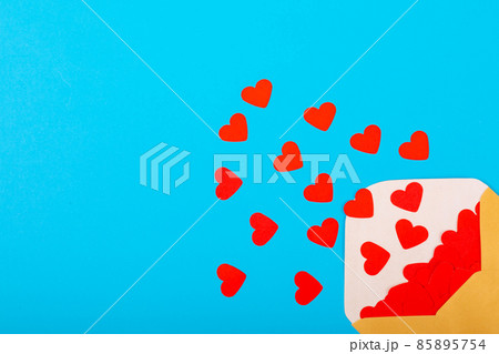 Open beige envelope with red heart shapes by copy space on blue background Open beige envelope with red heart shapes by copy space on blue background 85895754