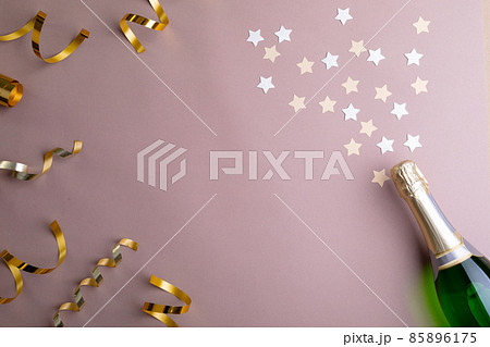 Overhead view of decoration and champagne bottle isolated on pink background, copy space 85896175