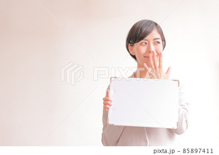 メッセージボードを持ち手を口に当てる女性2 85897411