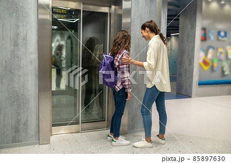 Joyful woman and a kid waiting for the passenger lift 85897630