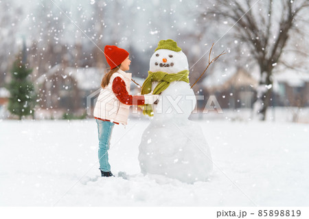 girl playing with a snowman girl playing with a snowman 85898819