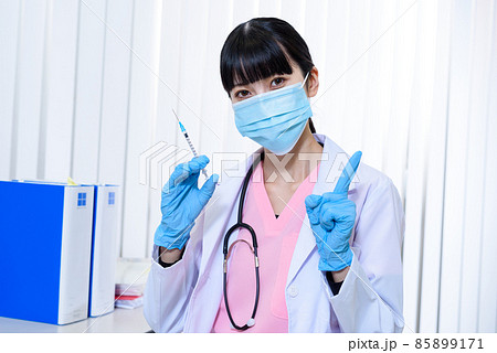 診察室でワクチン接種の注射器を持つ、スクラブを着てマスクをした女性医療従事者 外来 診察 診察室でワクチン接種の注射器を持つ、スクラブを着てマスクをした女性医療従事者 外来 診察 85899171