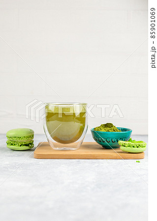 Green matcha tea in a glass glass and green macaroon cakes. Close-up on a light background. Copy of the space 85901069