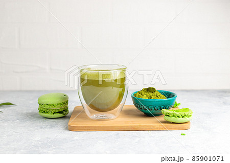 Green matcha tea in a glass glass and green macaroon cakes. Close-up on a light background, horizontal. Copy of the space Green matcha tea in a glass glass and green macaroon cakes. Close-up on a light background, horizontal. Copy of the space 85901071