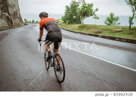 male cyclist riding his bike in country side shoot from the back male cyclist riding his bike in country side shoot from the back 85902416