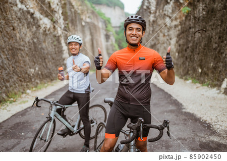 asian cyclist showing thumb up and smile to camera asian cyclist showing thumb up and smile to camera 85902450