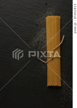 pasta concept a bundle of long slim pasta being placed on the black background 85902814