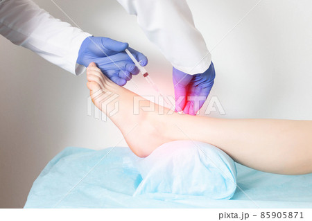 Doctor orthopedist makes an injection with blockade medication for cartilage regeneration and metabolism, close-up 85905871
