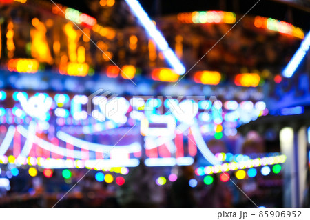 Defocused bright lights flash at a fun carnival at night. Amusement Park Bokeh Lights at Night. Nightlife entertainment Defocused bright lights flash at a fun carnival at night. Amusement Park Bokeh Lights at Night. Nightlife entertainment 85906952