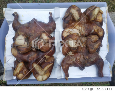 Delicious smoked chickens lies on a tray on foil. 85907151