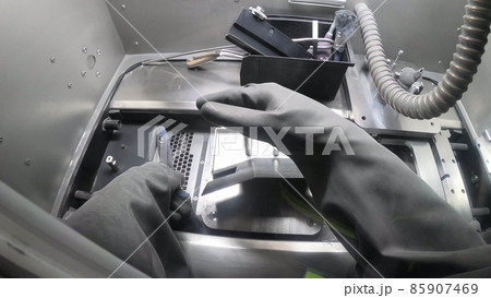 Male worker in rubber glove cleans printing platform inside 3d printer for metal Male worker in rubber glove cleans printing platform inside 3d printer for metal 85907469