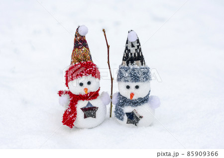 Merry christmas and happy new year greeting card with copy space Happy two little snowmen in red, blue cap and scarf standing in winter snow background Xmas fairytale Hello January, February concept 85909366
