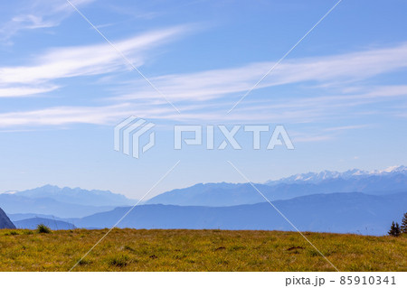 Alpine meadow on the plateau in Seiser Alm and morning fog covering the mountain ranges 85910341