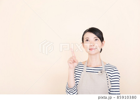 指で指し示すエプロンの女性 85910380