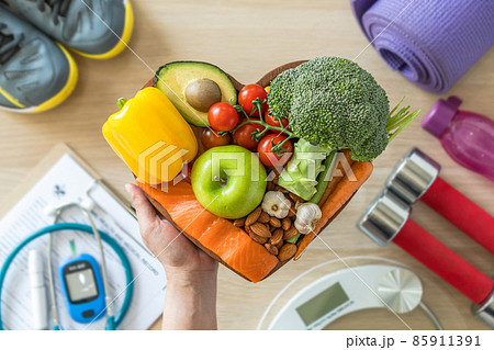 Healthy lifestyle on ketogenic diet, eating clean keto food good health dietary in heart dish with aerobic body exercise, gym workout training class , weight scale and sports shoes in fitness center 85911391