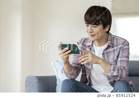 スマートフォンの画面を見る30代の男性 スマートフォンの画面を見る30代の男性 85911524