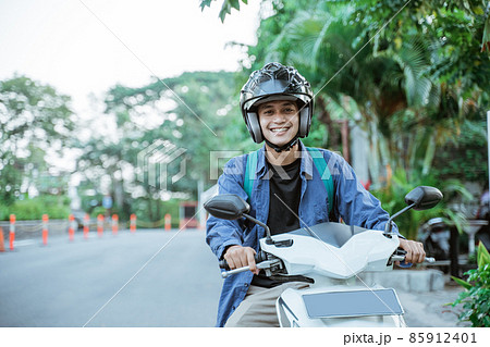 Asian man riding a motorcycle on the street 85912401