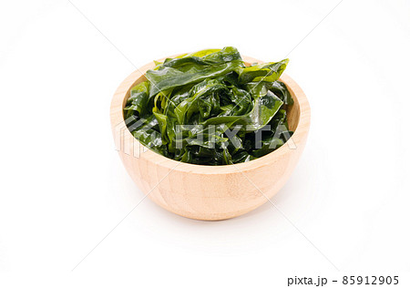 Fresh seaweed wakame in woodle bowl isolated on white background. Copy space. Japanese food Fresh seaweed wakame in woodle bowl isolated on white background. Copy space. Japanese food 85912905