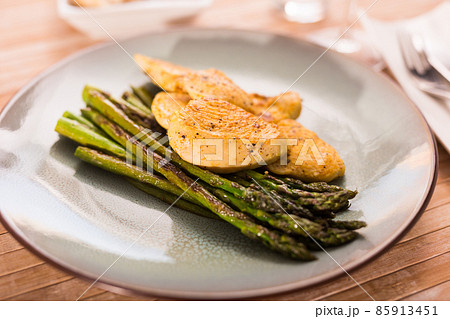 cooked dish. Chicken nuggets with green asparagus on plate 85913451