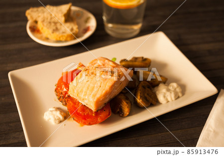 steamed sea trout fillet served on fried mushrooms with tomatoes on a white plate steamed sea trout fillet served on fried mushrooms with tomatoes on a white plate 85913476
