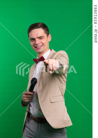 Portrait of professional male reporter holding a microphone, isolated on white and green background 85913663