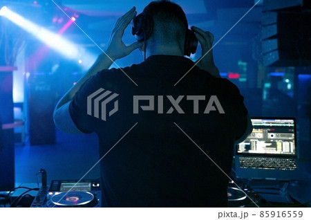 Dj mixing at party festival with light and smoke in background - Summer nightlife view of disco club 85916559