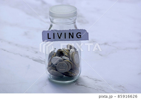 Blurred background of glass jar with multicurrency coins and text on white torn paper 85916626