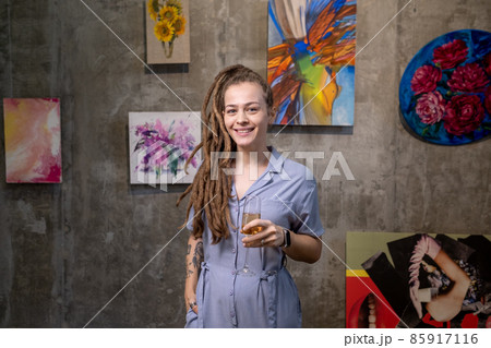 Happy young female with dreadlocks toasting with flute of champagne 85917116