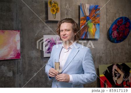 Contemporary mature man in elegant suit holding flute of champagne Contemporary mature man in elegant suit holding flute of champagne 85917119