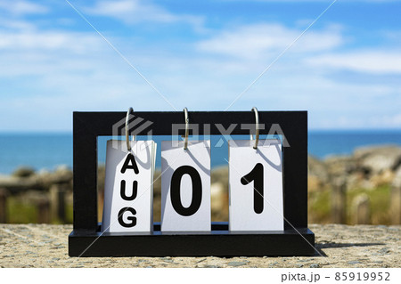 Aug 01 calendar date text on wooden frame with blurred background of ocean 85919952