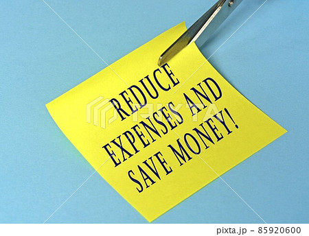 Scissors that cut yellow notepad with text on a blue background Scissors that cut yellow notepad with text on a blue background 85920600