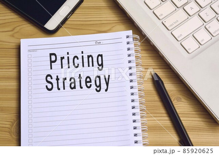 Pricing strategy label on notepad with laptop and smartphone on wooden table 85920625