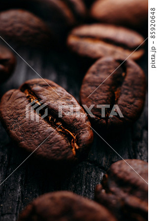 Close-up of coffee beans. Selective focus. Macro photo of coffee on dark textural background Close-up of coffee beans. Selective focus. Macro photo of coffee on dark textural background 85920648